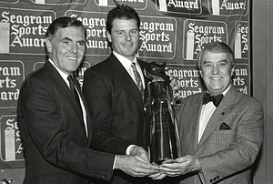 Mayor Raymond L. Flynn looking on as Boston Red Sox pitcher Roger Clemens recieves Seagram Sports Award from James P. Spillane of Seagram Distillers Co.