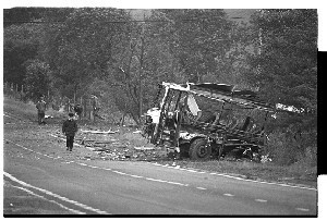 Ballygawley, Co. Tyrone bus bomb scene in which eight British soldiers were killed. Shots of mangled bus, crater where bomb exploded, helicopter and groups of soldiers near the site
