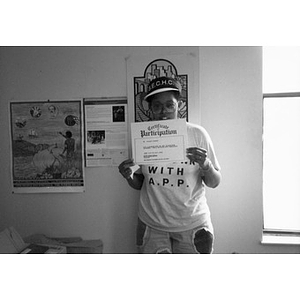 Young woman displaying her Certificate of Participation.
