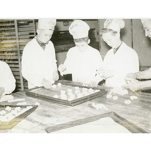 Members of the Tom Pappas Chefs' Club prepare foodstuffs on sheet pans