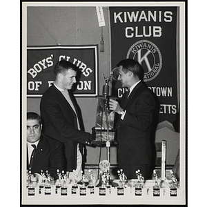 Richard Harte, Jr., presents an award to a young man at a Kiwanis Club's awards ceremony