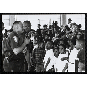 Boston Police officers perform with microphones for children at public relations event