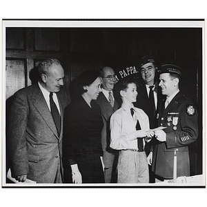 A boy poses with a veteran as two unidentified men, Executive Director Arthur T. Burger (far left) and Barbara Sherman Burger (2nd from left) look on at a Tom Pappas Chefs' Club event