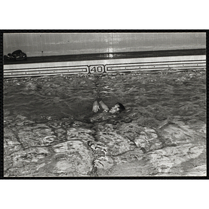 A boy swims in a natorium pool