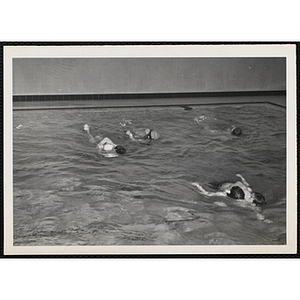 Boys practice rescue maneuvers in a natatorium pool
