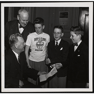 Mayor John B. Hynes (seated) and Executive Director of Boys' Clubs of Boston Arthur T. Burger pose with three boys