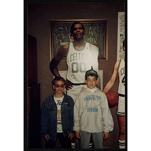 Two boys pose in front of a life-size cutout of the Boston Celtics' Robert Parrish in the New England Sports Museum