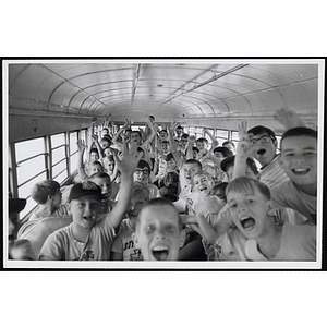 Boys pose for a candid group shot on a school bus