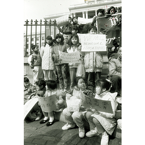 Asian American children hold protest signs at a rally for bilingual education outside the Massachusetts State House