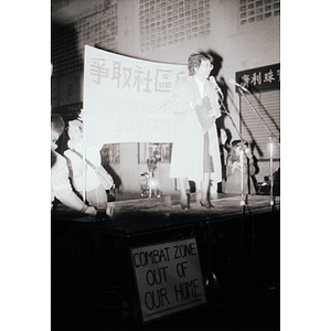 Asian woman stands on a makeshift stage and speaks at an evening demonstration in Chinatown advocating to take back the community from the infamous Combat Zone, the red-light district in Boston