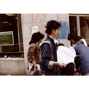 Community volunteers stand at a table on the corner of Beach Street and Harrison Avenue collecting signatures for Long Guang Huang