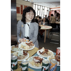 Chinese Progressive Association youth member holds a plate of food from a buffet line