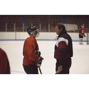 Hockey coach instructing one of his players during practice