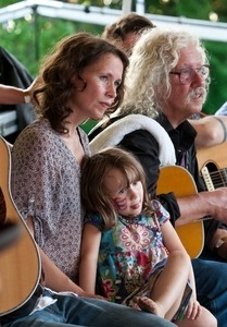 Sarah Lee Guthrie with young girl and Arlo Guthrie on stage at the Clearwater Festival