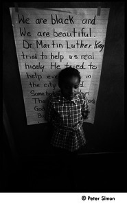 Young girl at the Liberation School, standing in front of a poster honoring Martin Luther King: 'We are black and beautiful. Dr. Martin Luther King tried to help us real nicely...'