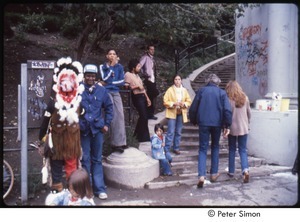 MUSE concert and rally: man in Native American ceremonial dress talking on a payphone