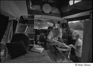 Ram Dass in his van: Ram Dass studying a map with Ronni Simon and an unidentified person