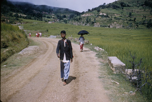 Young man walks down rural road