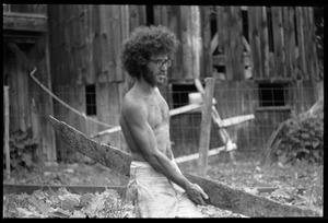 Marshall Bloom carrying a plank of wood outside the barn, Montague Farm commune