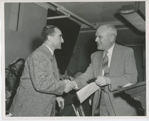 Unidentified man shaking hands with a graduate