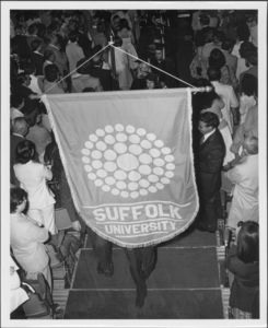 Graduates carrying Suffolk banner down aisle at the 1980 Suffolk University commencement