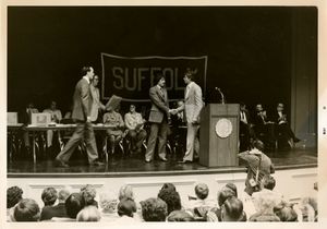 Athletics Director James E. Nelson on stage at Suffolk University's 1977 Recognition Day ceremony