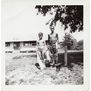 Two boys pose with sign pointing to the picnic grounds