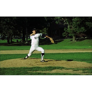 Baseball pitcher on the mound in a park.