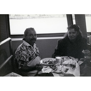Couple enjoying a meal on board a Boston Harbor Cruises boat on an outing organized for Villa Victoria residents.