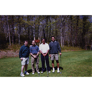 A four-man golf team posing on the golf course at the Charlestown Boys and Girls Club Annual Golf Tournament