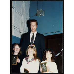 Former Boston Celtic Dave Cowens posing for a group picture with three girls at a Kiwanis Awards Night