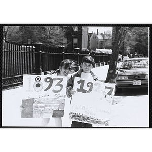 Two girls posing with their parade signs during the Boys and Girls Clubs of Boston 100th Anniversary Celebration Parade