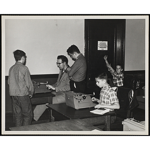 A man tutors boys in a typrwriting class