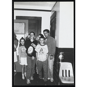 Site coordinator Josh Kraft and four children gather in a room for the Tri-Club slide show at the Charlestown Clubhouse