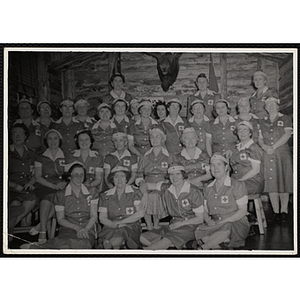 Twenty-eight women wearing red cross uniforms posing for a group picture