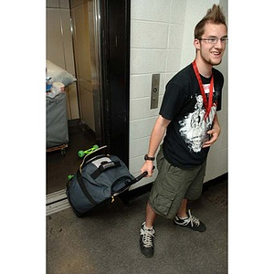 Jordan Munson brings belongings off the elevator during move-in