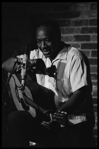 Josh White performing on guitar in a coffeehouse