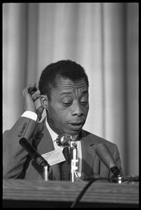 James Baldwin, seated on a panel at the Youth, Non-Violence, and Social Change conference, Howard University