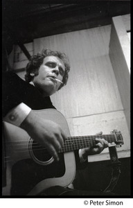 Tim Hardin smoking a cigarette and playing guitar at the Unicorn Coffee House, Boston, Mass.