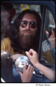 Krishna Das sitting inside a car, wearing sunglasses