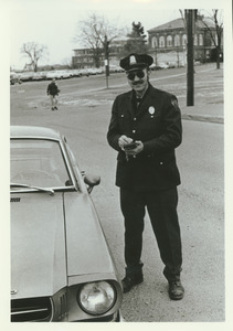 Unidentified police officer writing parking ticket