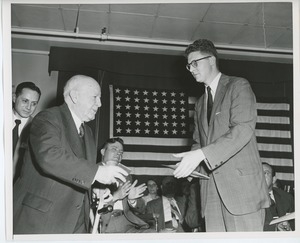 Unidentified man presenting gift to client on stage at Institute Day