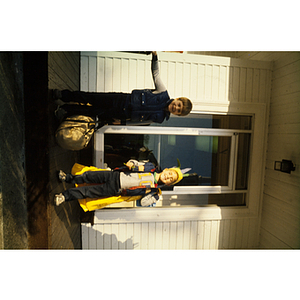 Boys standing at a door and holding luggage