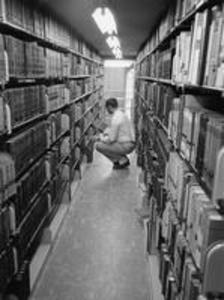 A student searches for books in the Stetson Library stacks