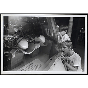 Two boys view an "Apollo Moon Capsule" exhibit in a museum