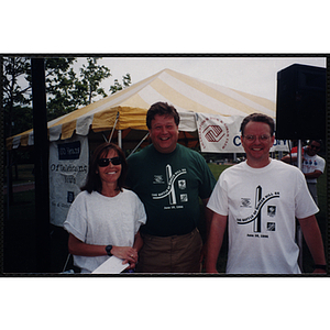 A woman poses with two men at the Battle of Bunker Hill Road Race