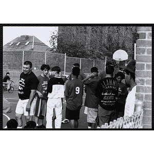 Players congregate courtside at a Chelsea Housing Authority Basketball League game
