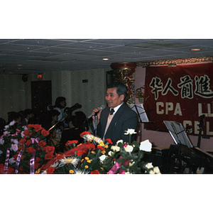 Man addresses a group gathered to celebrate the Lunar New Year