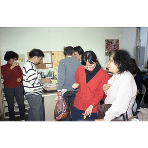 Men and women at the Chinese Progressive Association office for a celebration of the Chinese New Year