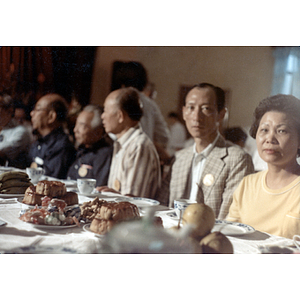 Men and women sit at a banquet table during a dinner party